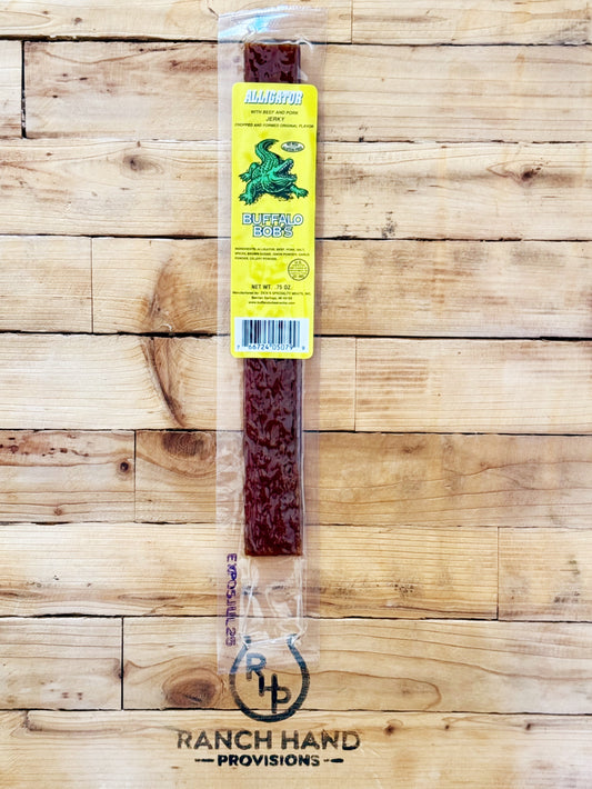 Packaged alligator jerky on a wooden background, with the brand logo 'Ranch Hand Provisions' visible on the packaging.